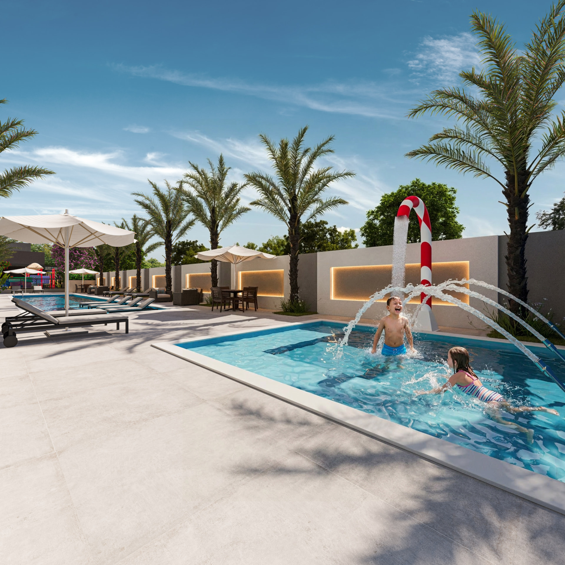 Crianças brincando na piscina infantil do Sky Breeze com jatos de água, guarda-sóis e palmeiras